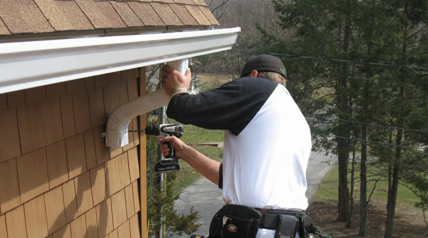 Professional contractor installing tan vinyl siding panels on a residential home exterior in Boulder, CO